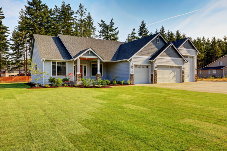 roofing tallahassee fl Luxury blue house with curb appeal. Three car garage with driveway . And freshly mowed garden lawn.