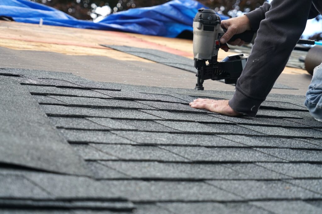 roof repair cost handyman using nail gun to install shingle to repair roof