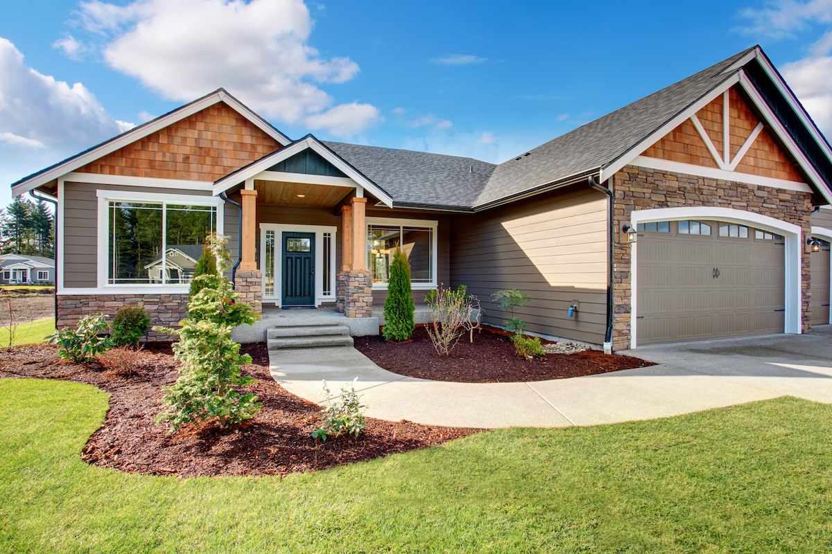 Large modern house with walkway and lots of grass.