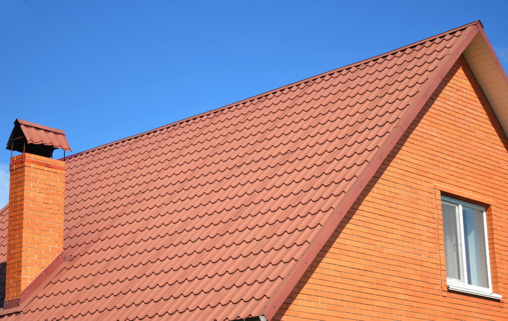 tile roof cost Old faded red metal roof tile blue sky