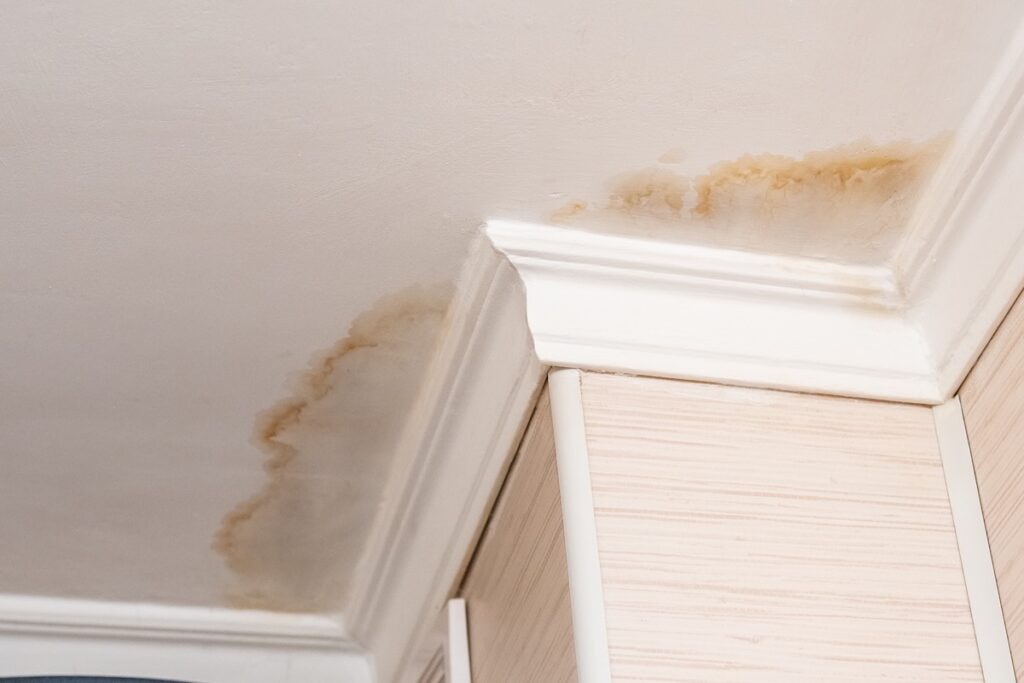 ceiling leak Neighbors have a water leak, water-damaged ceiling, close-up of a stain on the ceiling.
