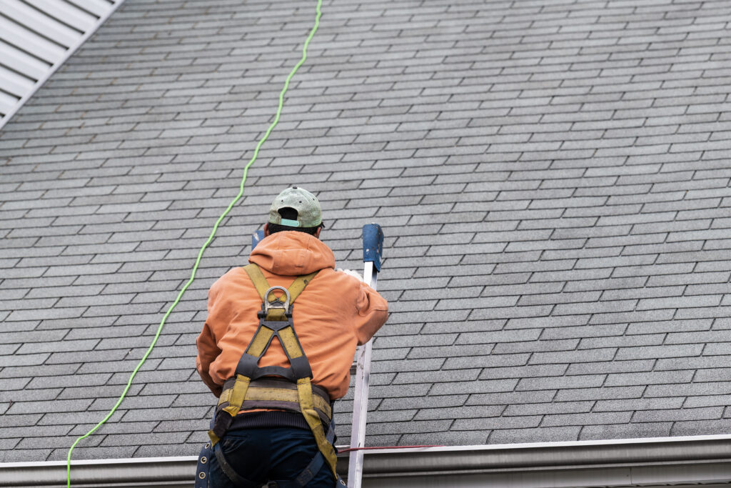 how to measure a roof for shingles House during day with gray color Single Family Home and man walking on roof shingles and ladder during repair